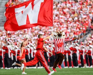 Members of the UW Spirit Squad wave a giant W flag and UW mascot Bucky Badger runs on the field to celebrate the start of a football game between the Wisconsin Badgers and the University of Michigan Wolverines at Camp Randall Stadium at the University of Wisconsin-Madison on Oct. 2, 2021.